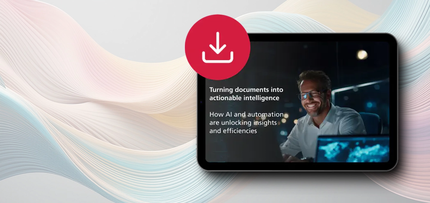 A smiling man in glasses works on a computer in a dimly lit office. Text reads: 