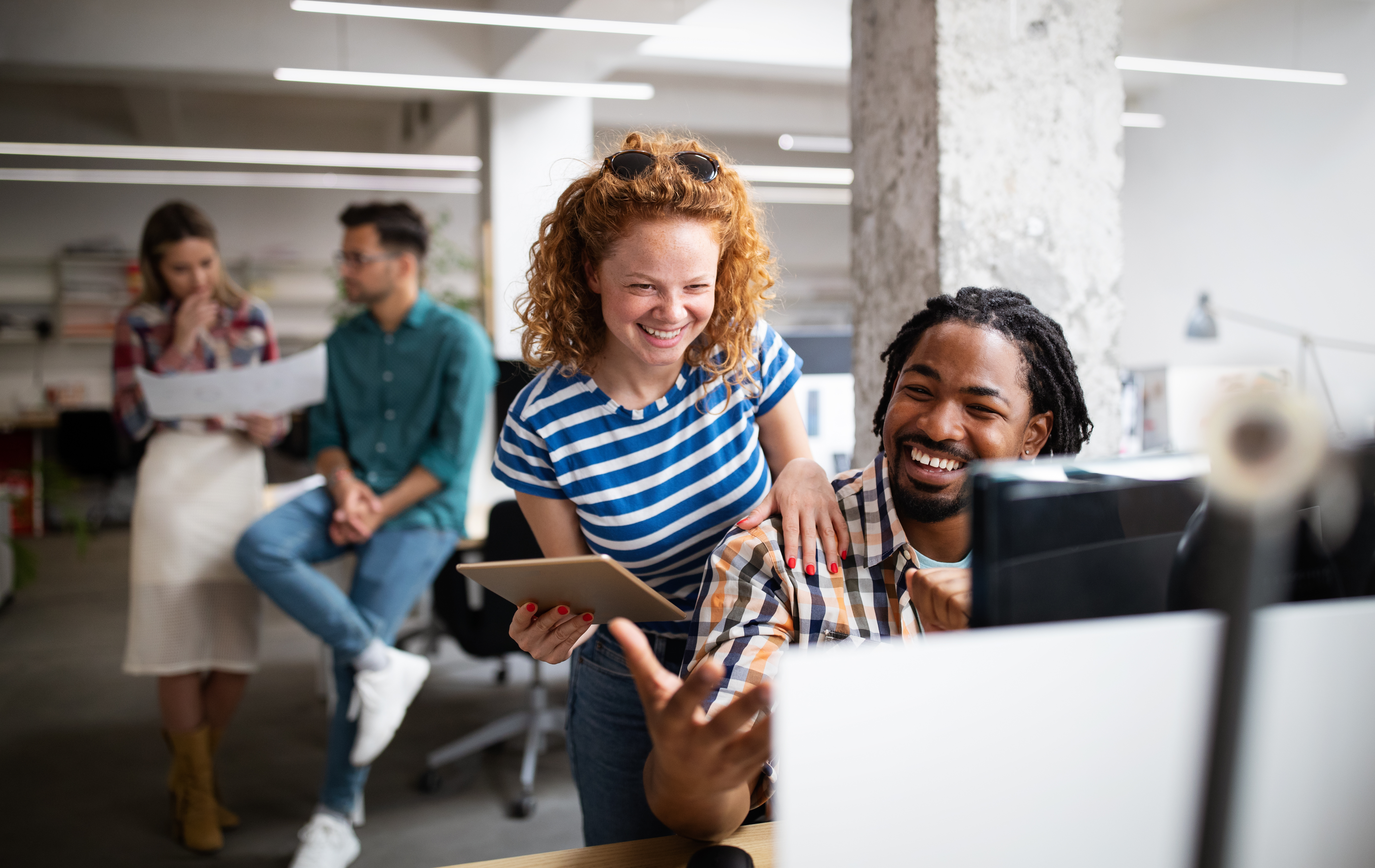 people smiling looking at a laptop